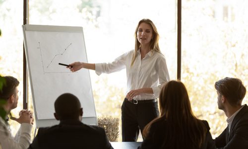 Woman presenting flip chart to small group