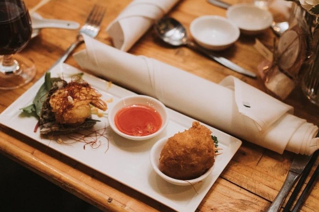 photo of dinner presentation with fried prawn dumpling and sauce